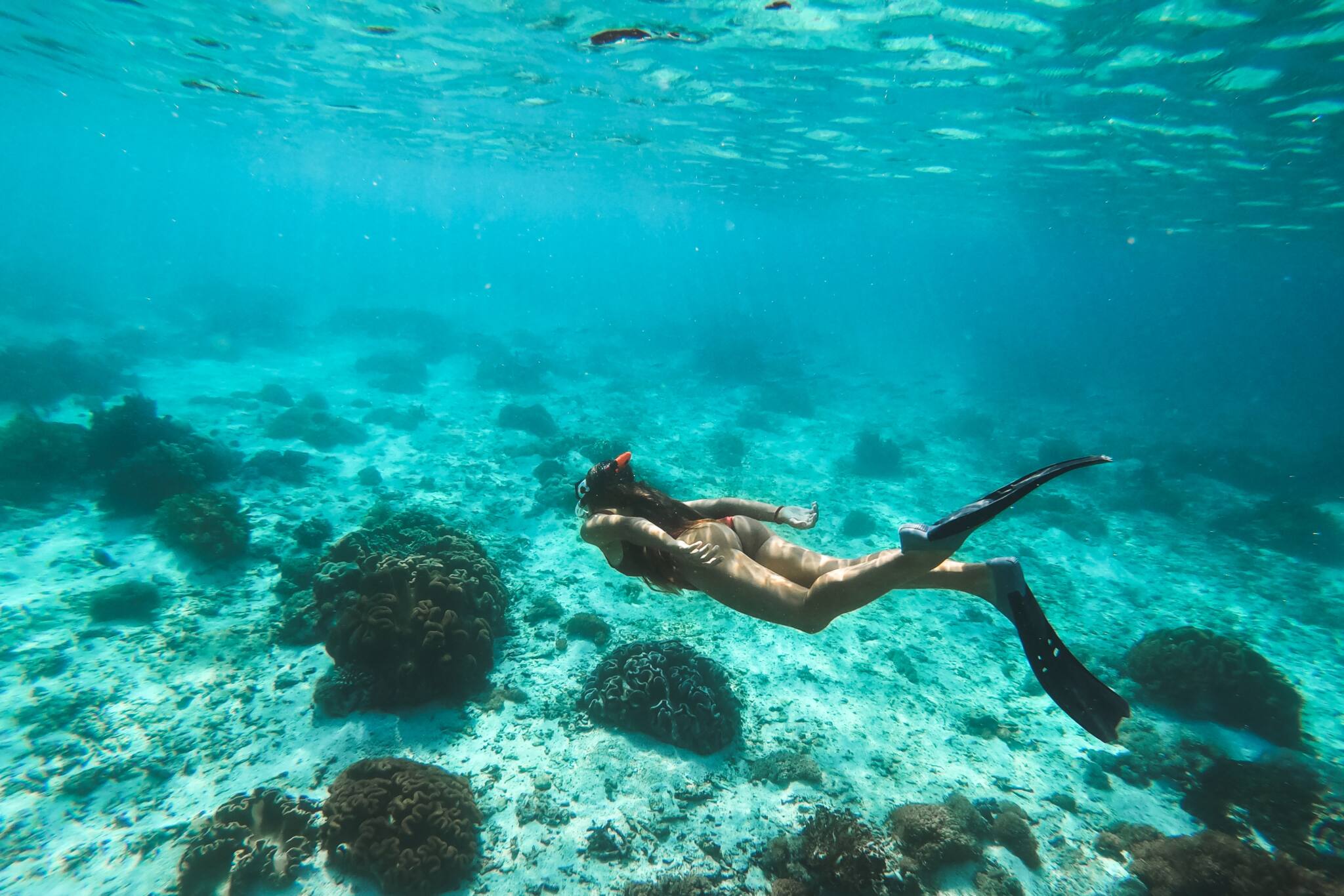 Woman snorkelling underwater with snorkel mask in clear transpar